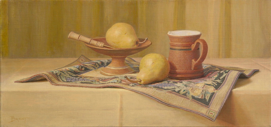 A small plate of pears and a terra-cotta cup on a mat